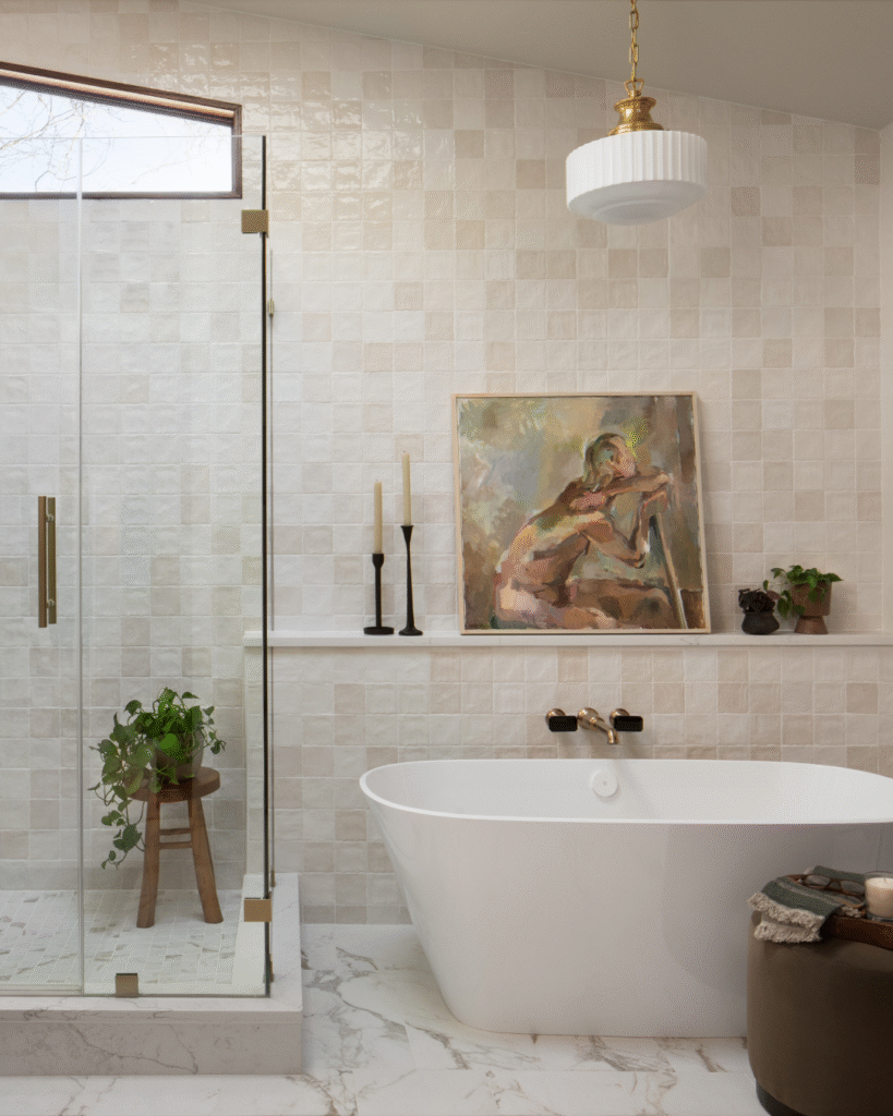 This spa-inspired bathroom layers soft light neutrals with rich earth tones for a look that’s both grounded and elevated. Featuring a bold portrait as the focal point, the space is a masterclass in organic modern design.